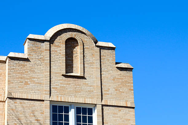 cima di un edificio in mattoni decorativi panna - mullions foto e immagini stock