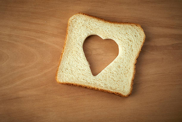 istock Slice of bread with cut out heart shape 464401295