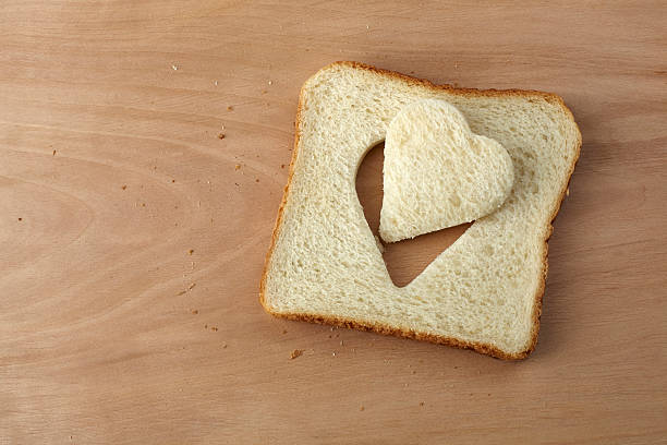 istock Slice of bread with cut out heart shape 464402763