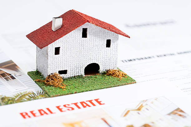 istock Small toy house on real estate documents. 464403973