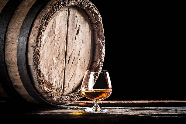 Old barrel and a glass of cognac Old barrel and a glass of cognac. cognac stock pictures, royalty-free photos & images