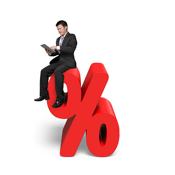istock Using tablet businessman sitting on red percentage sign 464410146
