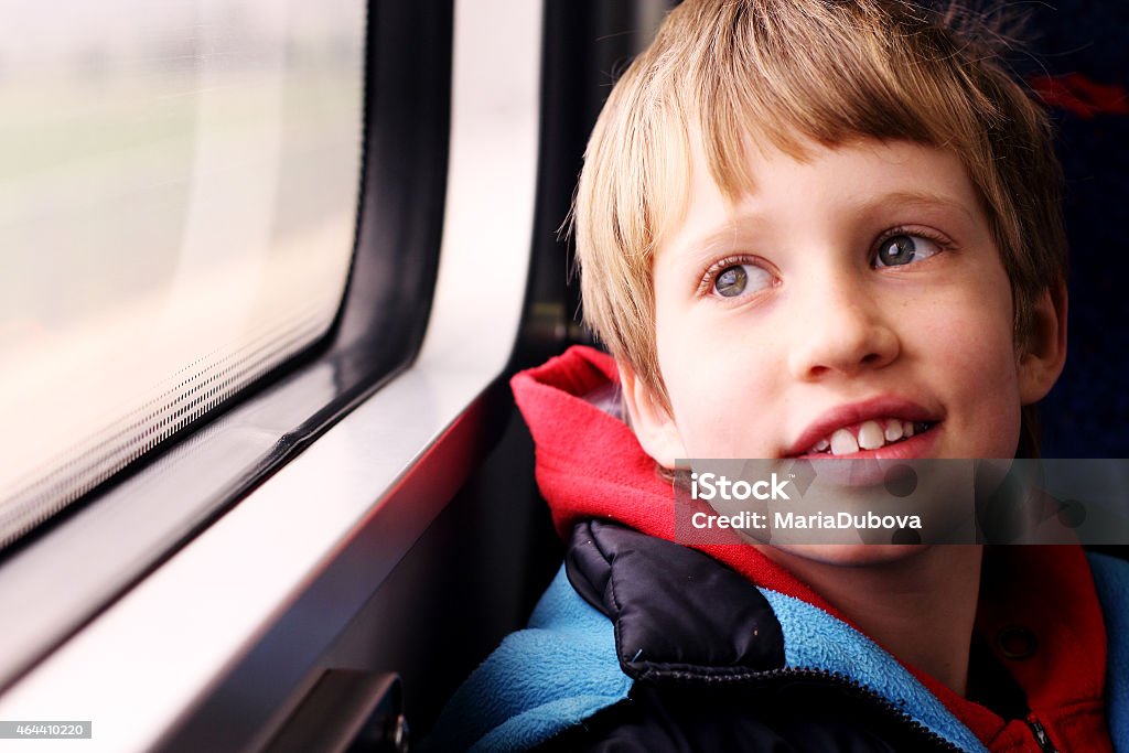 Cute Boy looking through the window Cute Boy sitting in the train and looking through the window Autism Stock Photo