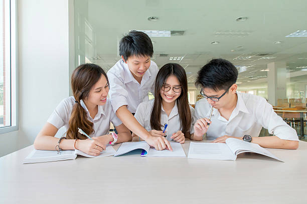 gruppe der asiatischen studenten in uniform im klassenzimmer lernen zusammen - adult student college student school uniform student stock-fotos und bilder