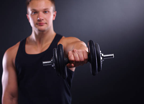 istock Handsome muscular man working out with dumbbells 464416168