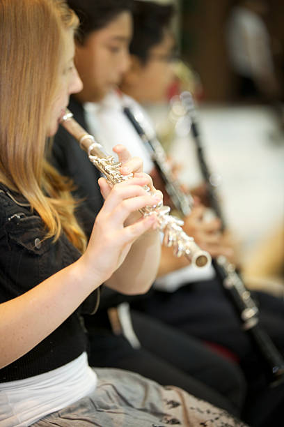 istock little girl playing flute with the orchestra. 464429982