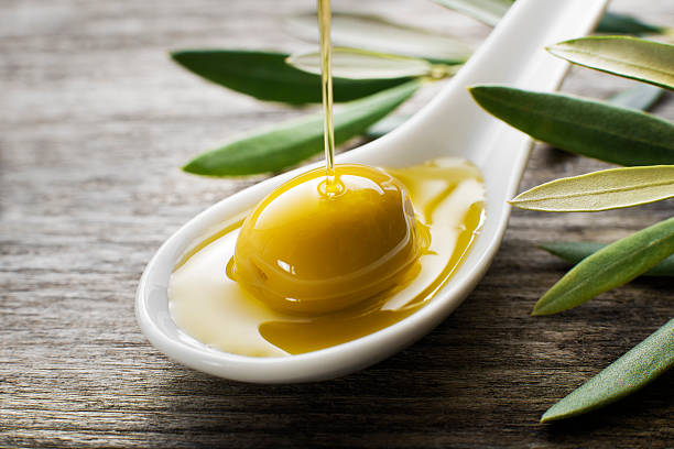 istock Olive oil being poured into white spoon 464430254