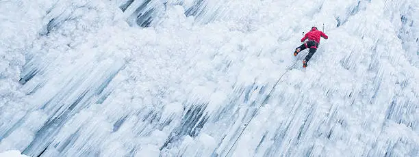 Ice climber ascending a frozen waterfall.