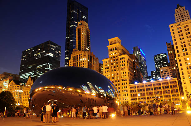 Chicago at night Chicago, IL, USA – August 8, 2014: People standing under the Cloud Gate at night, Chicago, IL, USA. neta degany stock pictures, royalty-free photos & images