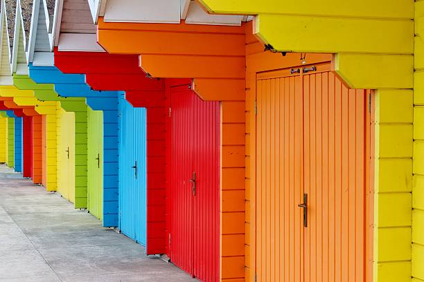 istock Colourful wooden beach huts in summer sun 464445871