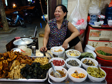 Hanoi, Vietnam - July 09, 2014: Met this happy food stall vendor during a walking tour of Hanoi's incredible street food scene