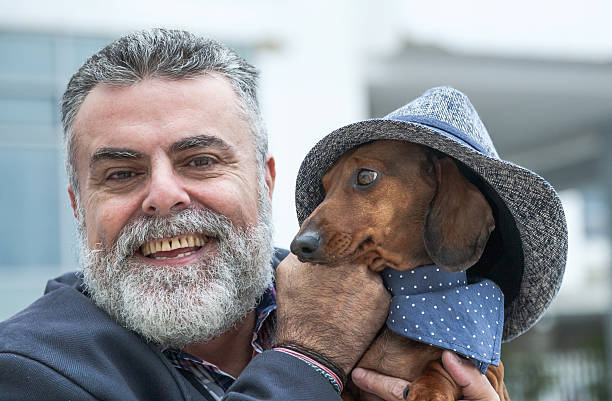 istock Attractive old man with beard and hat with dog 464446658