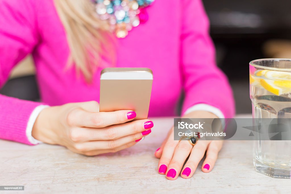 Woman using mobile phone in cafe Young woman using mobile phone in cafe 2015 Stock Photo