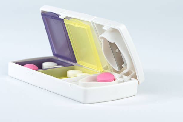 istock Closed up aluminum blade and pink tablet in pill box 464448198