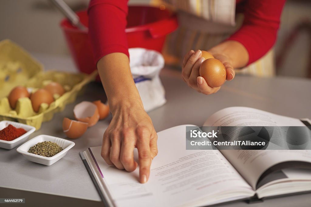 Closeup on happy housewife preparing christmas dinner in kitchen Closeup on happy young housewife preparing christmas dinner in kitchen Cookbook Stock Photo