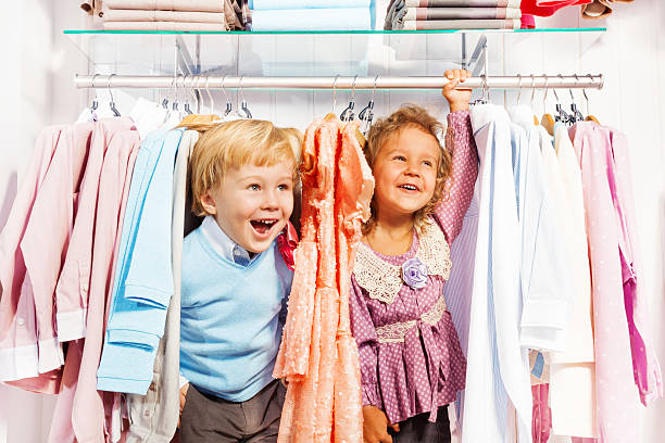 feliz menino e menina brincar de esconde-esconde na loja - child clothing arrangement hanger - fotografias e filmes do acervo