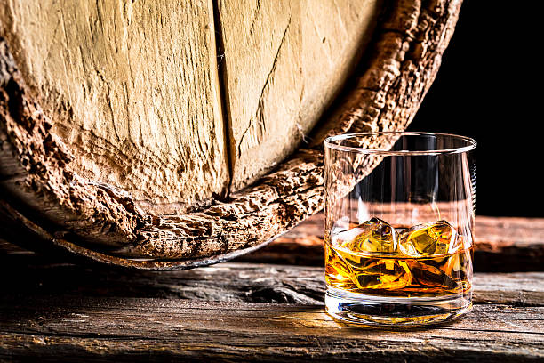 istock Whiskey glass and old oak barrel 464454700