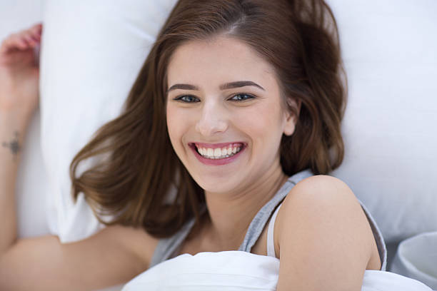 istock smiling woman lying on the bed 464457184