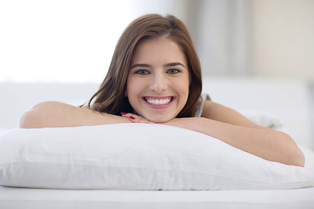 istock cheerful woman lying on the bed at home 464460934