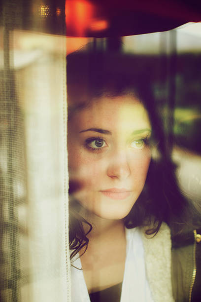istock Teenager looking through window 464460985
