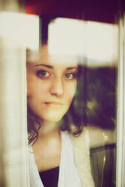 istock Teenager looking through window 464461005