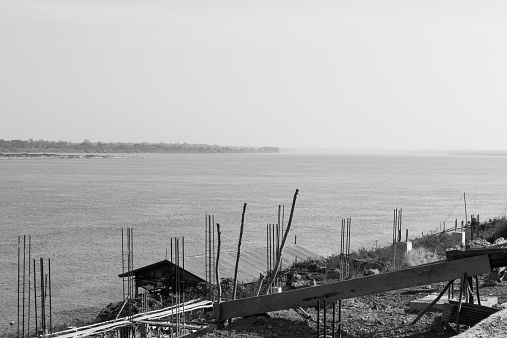 the pier beside Mekong river is under construction in Nakhon Phanom near the border between Thailand and Laos, black and white