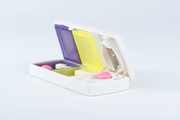 istock Closed up aluminum blade and pink tablet in pill box 464465796
