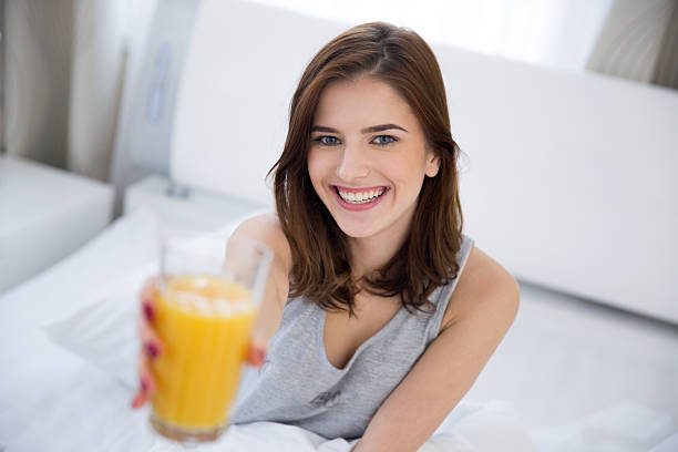istock woman holding orange juice 464471092
