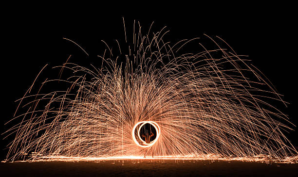 Firestarter performing amazing fire show with sparkles in the night Firestarter performing amazing fire show with sparkles in the night - Full moon party entertainment in thailand nightlife at the beach phuket beach party stock pictures, royalty-free photos & images