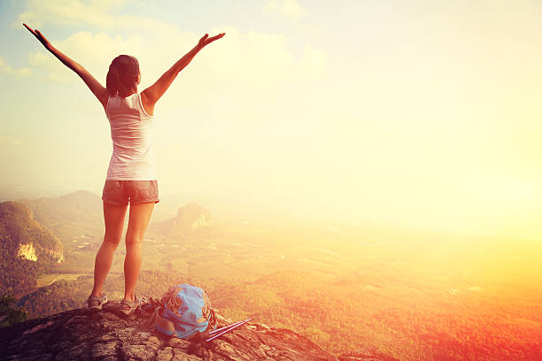 istock cheering hiking woman on mountain peak 464475346