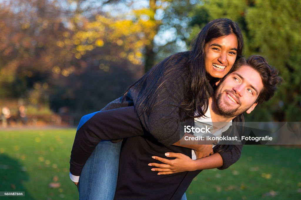 Woman sitting on boyfriends back in evening sun Woman sitting on boyfriends back in the evening sun 2015 Stock Photo