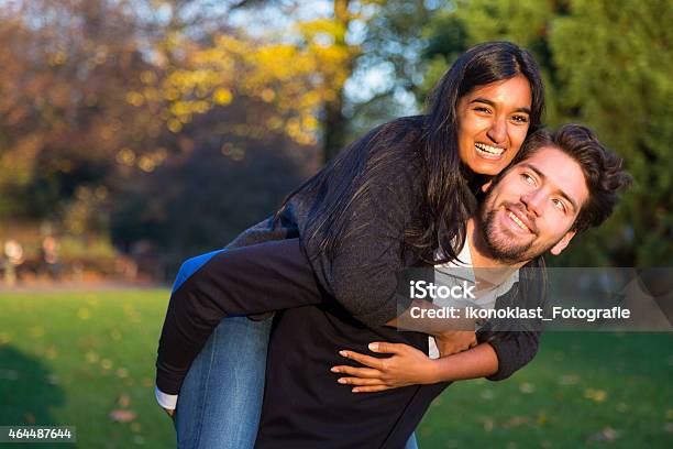 Woman Sitting On Boyfriends Back In Evening Sun Stock Photo - Download Image Now - 2015, Adult, Beautiful People