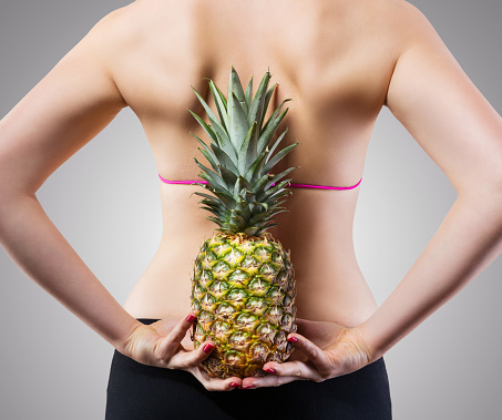 Unrecognizable fit woman with pineapple