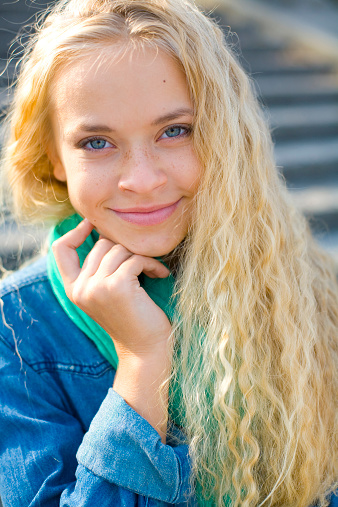 portrait of a smiling beautiful blond girl outdoors