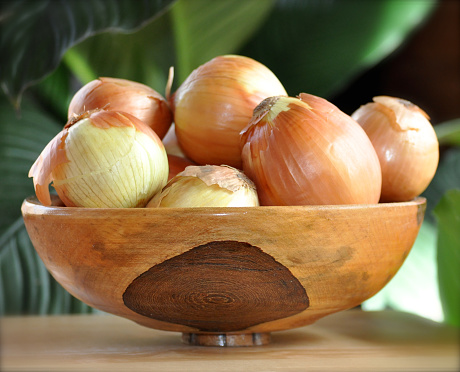 Wooden bowl of onions