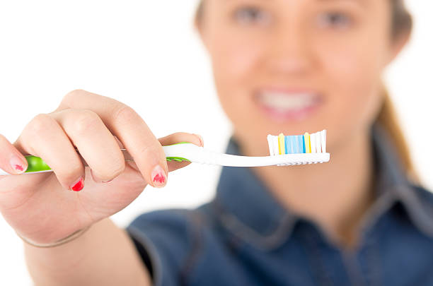 istock beautiful young smiling woman brushing teeth 464497552