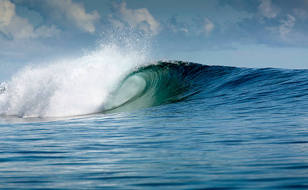istock Blue ocean surfing wave and clouds in blue sky 464497986