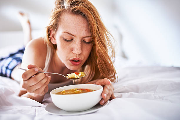 soplar en sopa de enfriar abajo en la cama - soup chicken soup chicken noodle soup food fotografías e imágenes de stock