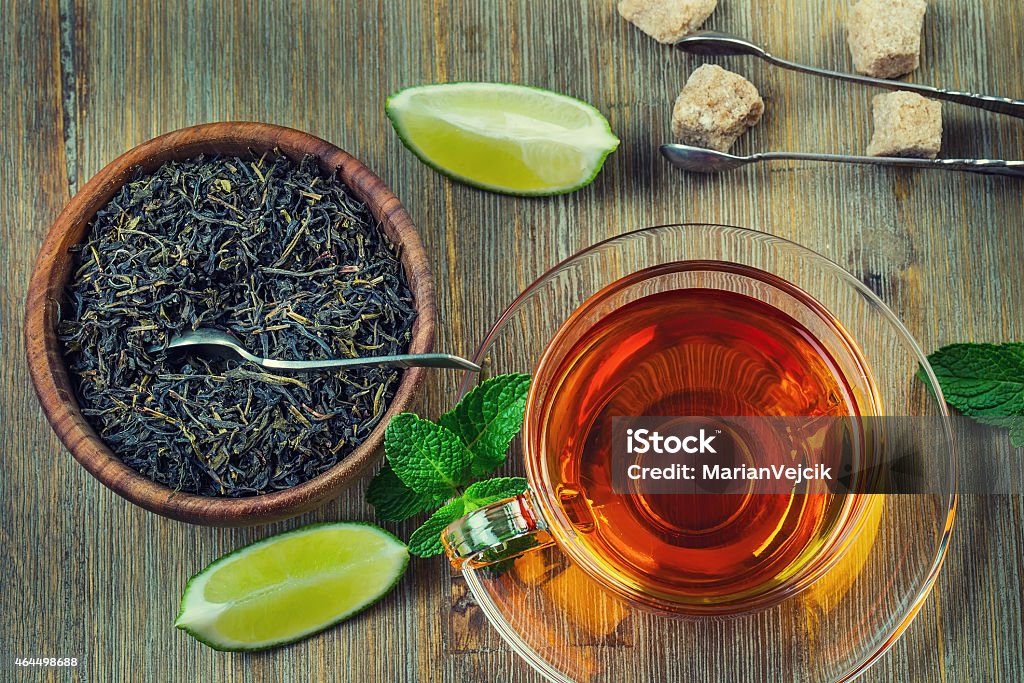 Tea in a glass cup, mint leaves Tea in a glass cup, mint leaves, dried tea, sliced lime, cane brown sugar Tea - Hot Drink Stock Photo