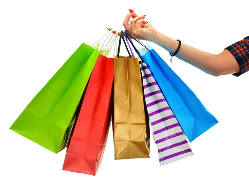 Female hand holding paper shopping bags isolated on white background