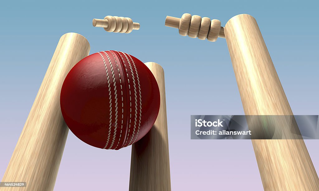 Cricket Ball Hitting Wickets A red leather cricket ball hitting wooden cricket wickets in the daytime Sport of Cricket Stock Photo