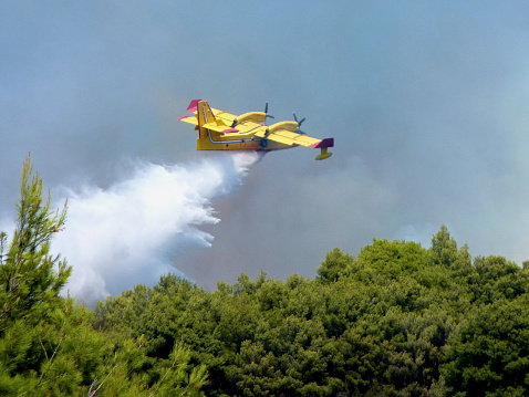 Ciovo, Croatia, August, 2012: Bombardier CL-415 Super Scooper 246 from Croatia makes a water drop on a wildfire in island Ciovo Croatia.