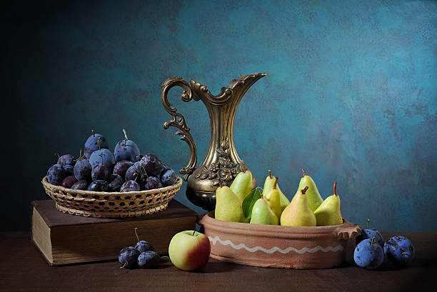 istock Pears, plums, books and a metal carafe 464529634