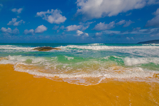 blue ocean waves and yellow sand
