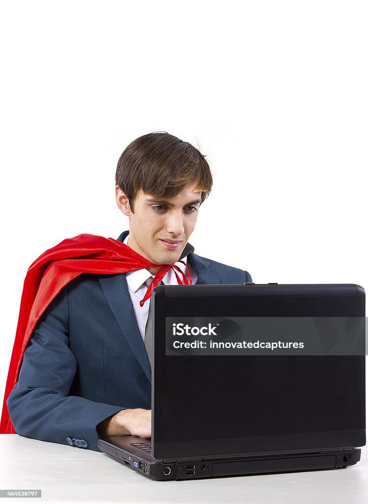 Super Businessman With a Red Cape Working on a Laptop young male businessman wearing a red cape Achievement Stock Photo