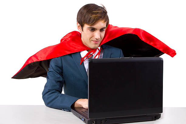 istock Super Businessman With a Red Cape Working on a Laptop 464538985