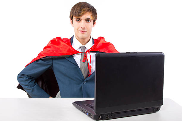 istock Super Businessman With a Red Cape Working on a Laptop 464542803