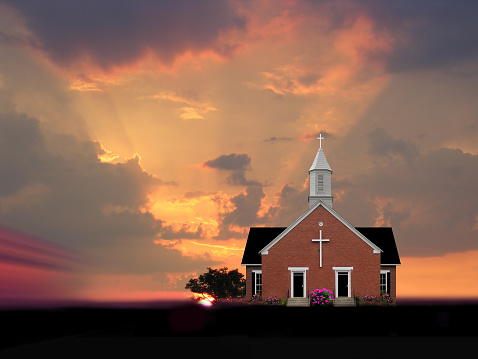 Little country church on the side of the road at sunset.