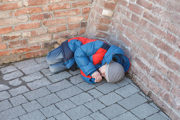 istock homeless boy leaned against the wall 464543512