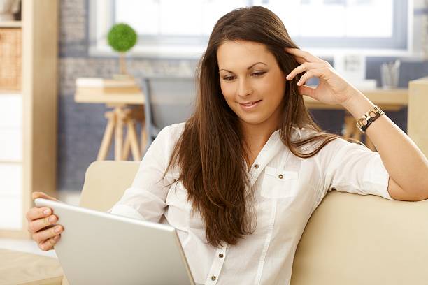 istock Young woman using laptop at home 464544499